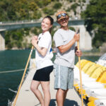 Un homme et une femme dos à dos tenant un ballet à la main sur un ponton
